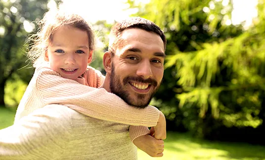Man carrying young girl on back